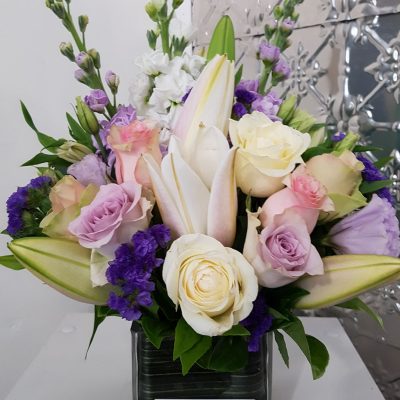 An arrangement of pastel flowers in a glass vase.